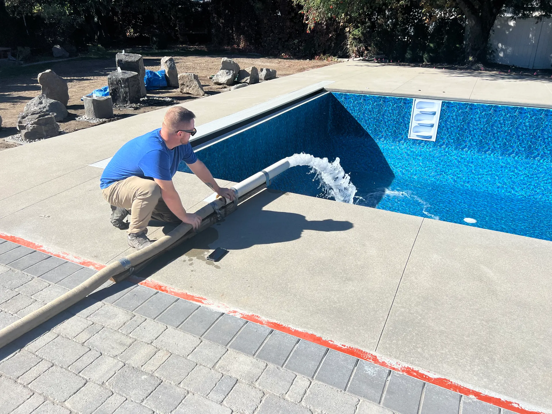 Vinyl-liner pool filling with water, return hose visible